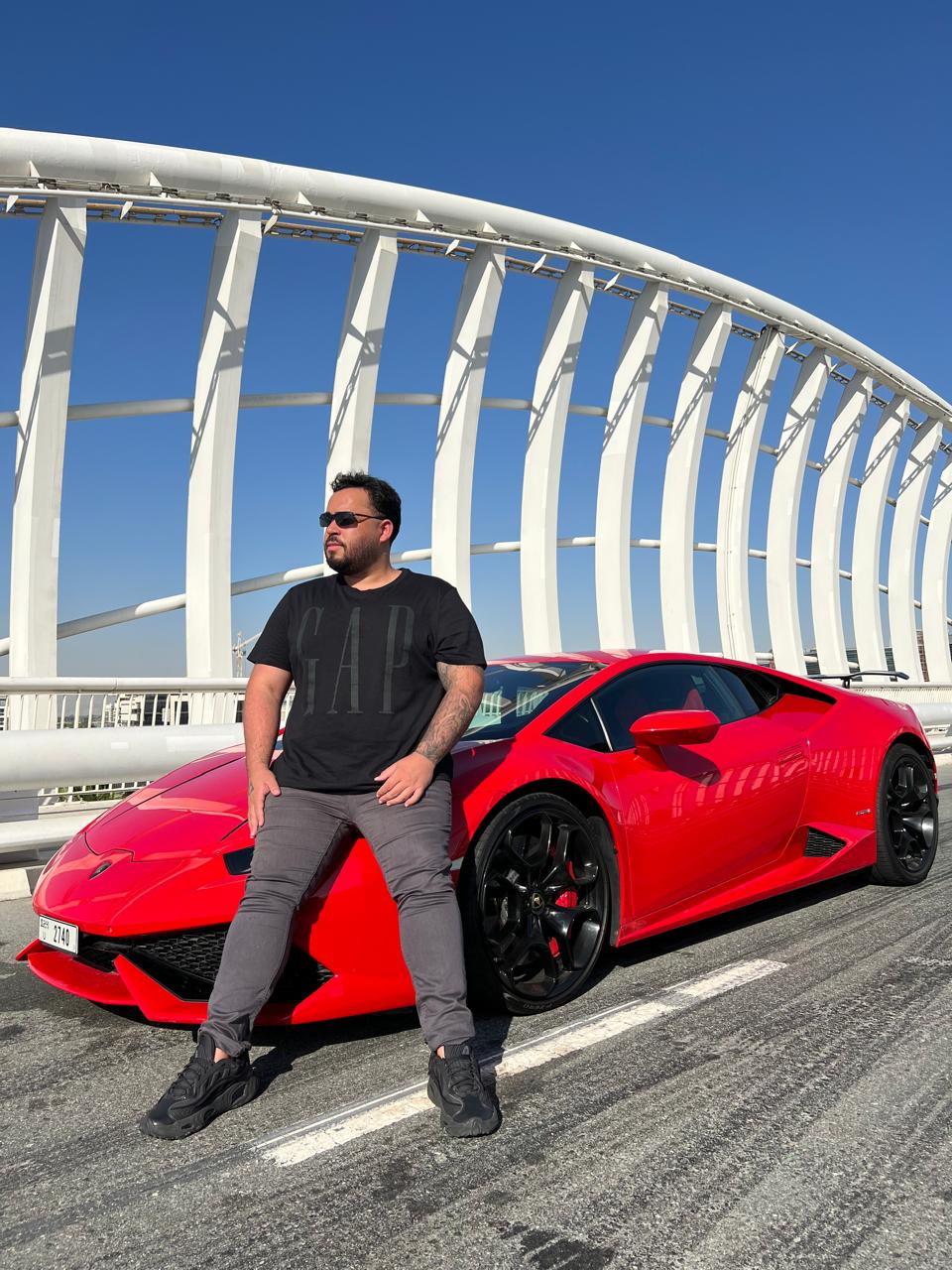 Apoiado em uma Lamborghini vermelha em ponte em Dubai